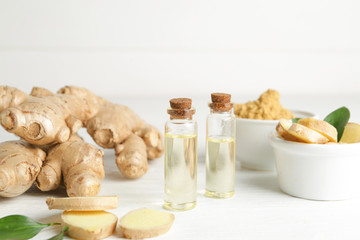 Bottles with ginger essential oil on wooden table