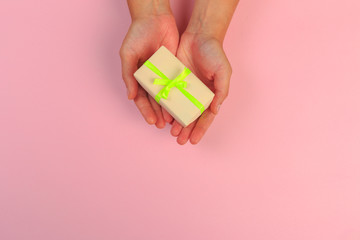 gift in female hands on a colored background top view. - Image