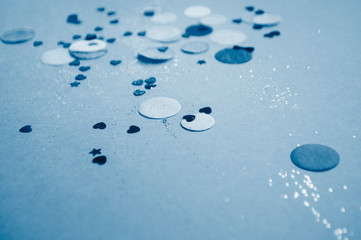 Blue confetti, sparkles on blue background. Festive background