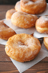 Fototapeta na wymiar Sweet tasty donuts on wooden background
