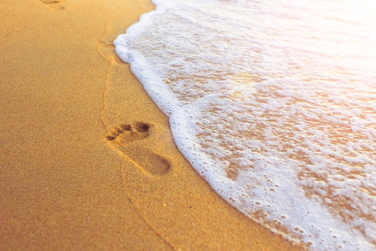 footprint of tourist feet on the sea beach sand for go walking travel in holiday.