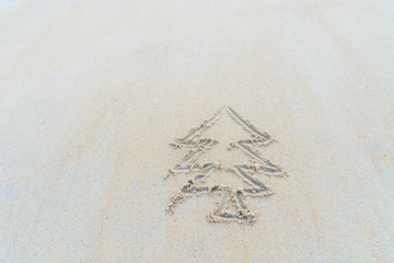 Concept Christmas on the beach Tropical design made in Phuket, Thailand Write the alphabet on the sand background Taken from real locations.