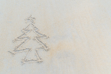 Concept Christmas on the beach Tropical design made in Phuket, Thailand Write the alphabet on the sand background Taken from real locations.