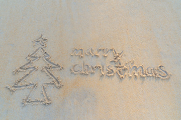 Concept Christmas on the beach Tropical design made in Phuket, Thailand Write the alphabet on the sand background Taken from real locations.