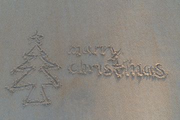 Concept Christmas on the beach Tropical design made in Phuket, Thailand Write the alphabet on the sand background Taken from real locations.