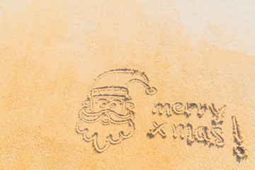 Fototapeta na wymiar Concept Christmas on the beach Tropical design made in Phuket, Thailand Write the alphabet on the sand background Taken from real locations.