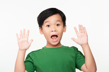 Portrait of joyful or surprised cute asian schoolboy with raised hands.