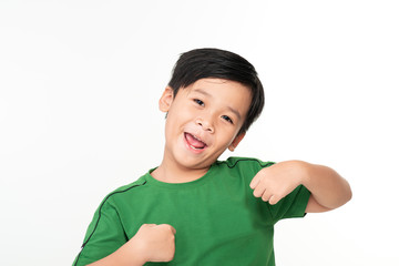 Portrait of cute smart young Asian boy shows winning gesture and smiling at camera, celebrating success victory against white background