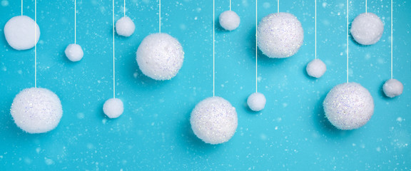 Fototapeta na wymiar Christmas composition. The concept of a winter festive background, snowfall from white balls on a blue background. Christmas, winter, new year concept. Banner Minimalism flat lay