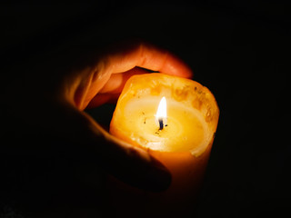Candle in the hands on a dark background. during the festival of light