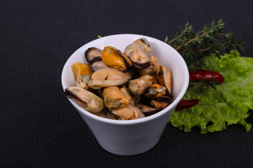 Pickled mussels in the bowl served pepper, garlic and salad