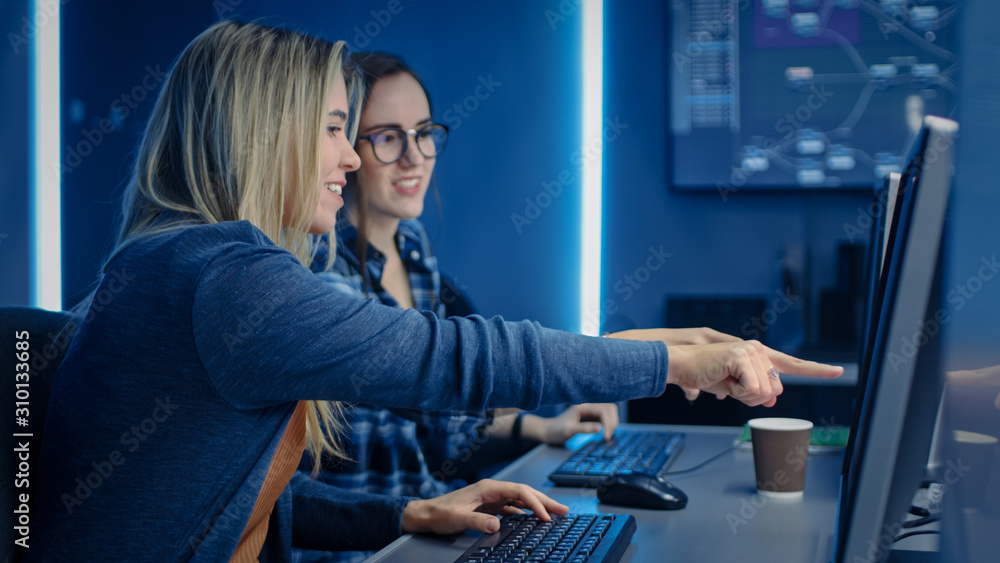 Poster Two Female IT Programers Working on Desktop Computer in Data Center System Control Room. Team of Young Professionals In Software and Hardware Development, Doing Coding