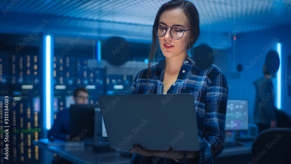 Poster portrait of a smart seductive young woman wearing glasses holds laptop. in the background technical 