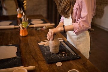 A master class in modeling a clay jug. The girl is engaged in modeling.