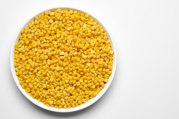 canned corn in white plate top view. white background