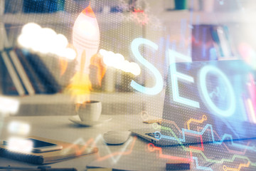 Multi exposure of table with computer and seo drawing hologram. Search optimization concept.