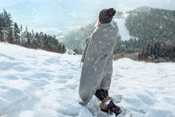 Happy woman traveler on the snowy of mountain look on the nice w
