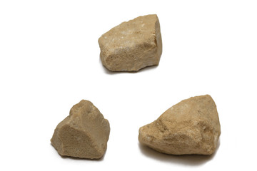 Three beige pebbles on a white background