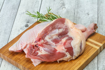 Raw duck leg served rosemary