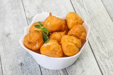 Sweet tasty profiteroles heap in the bowl