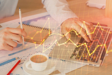 Forex graph with businessman working on computer in office on background. Concept of hardworking....