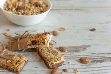 Cereal granola bar with nuts, fruit and berries on wooden table background. Healthy sweet dessert snack.