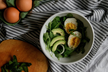 flat lay breakfast. Wholesome food, beautiful serving. Eggs, avocados and greens.