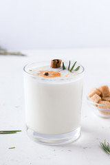 Lassi Indian milk yogurt drink on a white plate next to cane sugar. Fermented foods