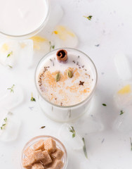 Milkshake with spices on a white plate next to cane sugar