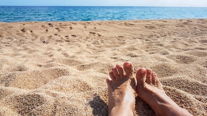 female feet on the beach and sand