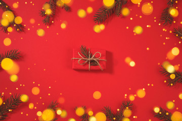 Fototapeta na wymiar Gift box. Christmas background with xmas tree and sparkle bokeh lights on a red background.