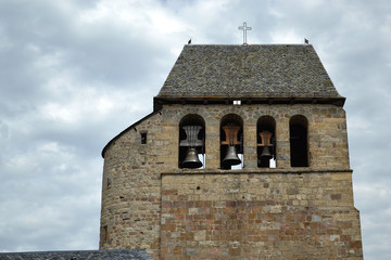Fototapeta na wymiar Église romane avec un clocher médiéval, clocher à arcades, clocher à peigne de l'église de Vimenet, Causse de Séverac, Aveyron, France
