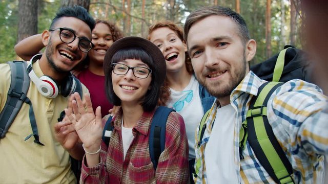 Point of view portrait of joyful young people friends taking selfie travelling in the forest together posing with funny gestures. Youth and self-portrait concept.