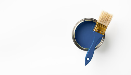 Can of Classic blue paint and brush on white background. Trendy color concept. Top view.