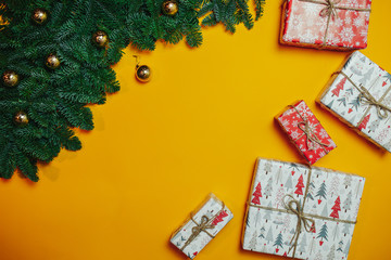 Christmas composition. Christmas gift, fir branches on orange background. Flat lay, top view, copy space