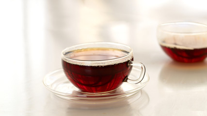 Glass of black tea on white background. Hot drink concept.