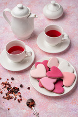 Heart shape cookies with icing with berry tea. Concept: Valentine's Day tea party, festive table setting in pink.