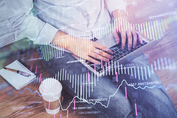 Multi exposure of market chart with man working on computer on background. Concept of financial analysis.