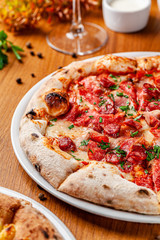 Italian food concept. Thin pizza with thick sides on a white plate. background image. copy space