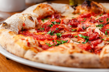 Italian food concept. Thin pizza with thick sides on a white plate. background image. copy space