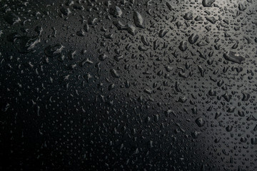 Water rain dropping on black background. 