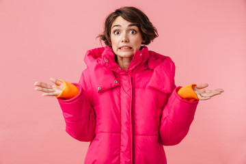 Portrait of confused woman throwing up hands and looking at camera