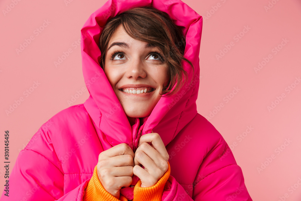 Wall mural Portrait of young pleased woman is freezing and smiling