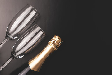 Minimal composition with champagne bottle and two glasses.