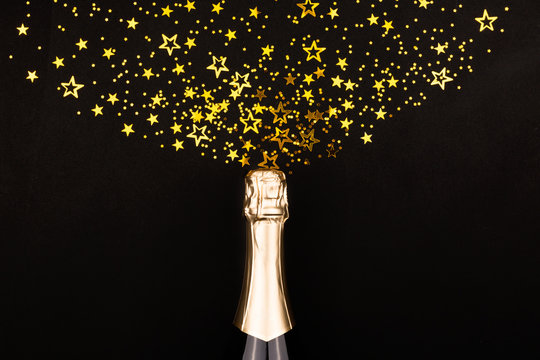 Creative New Year composition with champagne bottle and confetti.