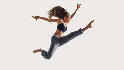 Fototapeta na wymiar Never stop run. Full length of young athlete woman with perfect body in sports clothing jumping