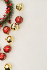 Christmas composition. Christmas decorations gold and red balls and tinsel on a light texture background.