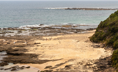Sydney, Australia, New South Wales, 12/15/2019. Norah Head Beach with a beautiful natural construction of stones forming a path as if receiving a boat. It resembles a pier. There some mountains around