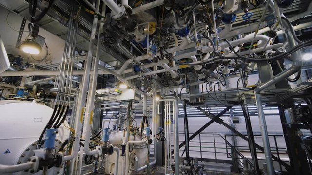 Interior of chemical factory. Modern equipment, steel tanks and boilers with cables, pipelines and valves for chemical mixing. Production of anti-turbulent additives used in the oil industry.