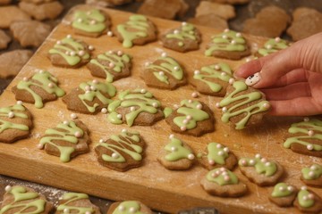 Christmas homemade gingerbread cookie sprinkled with green sugar on a wooden table and in hand